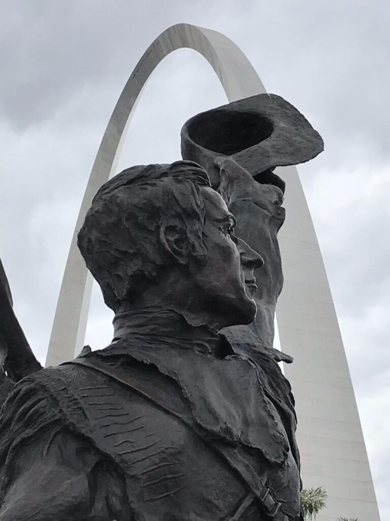 Statue of an explorer tipping his hat towards the Western Gateway